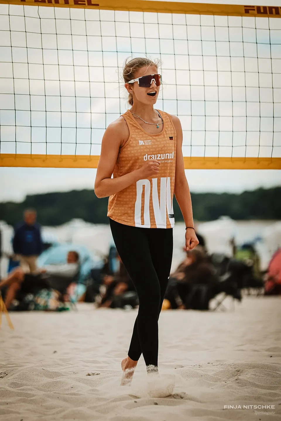 Beachvolleyballerin geht jubelnd über den Sand