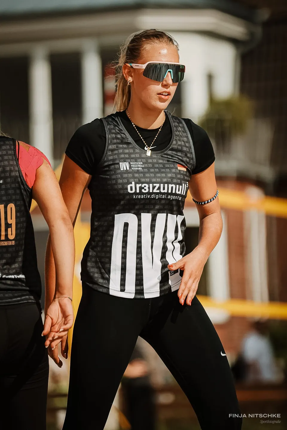 Beachvolleyballerin mit Sportbrille wartet konzentriert auf den nächsten Ballwechsel